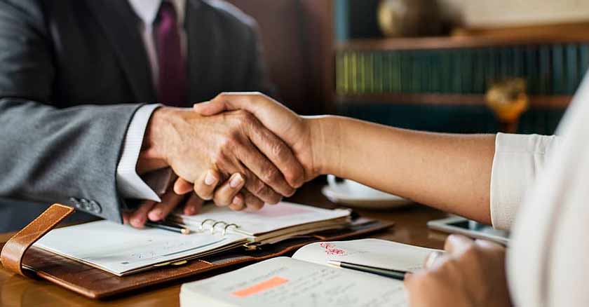 Abogados en escritorio dándose la mano
